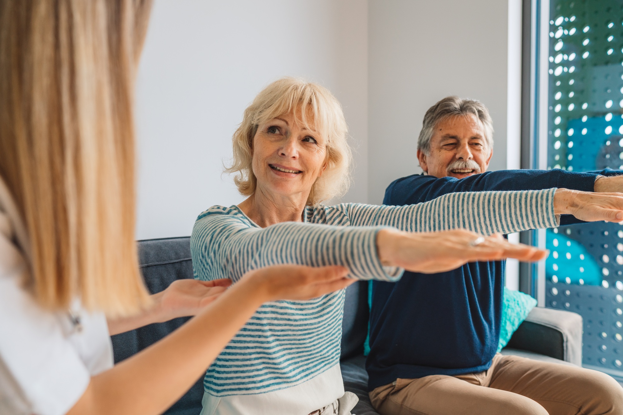 Senior couple on physiotherapy session with home caregiver